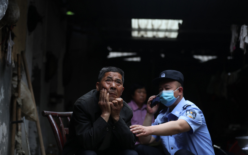 面對駐村輔警孫海濤的來訪，空巢老人易老爹（左一）望著屋外的水田發(fā)著愁。