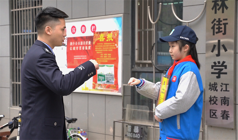 民警和孩子碰拳約定。