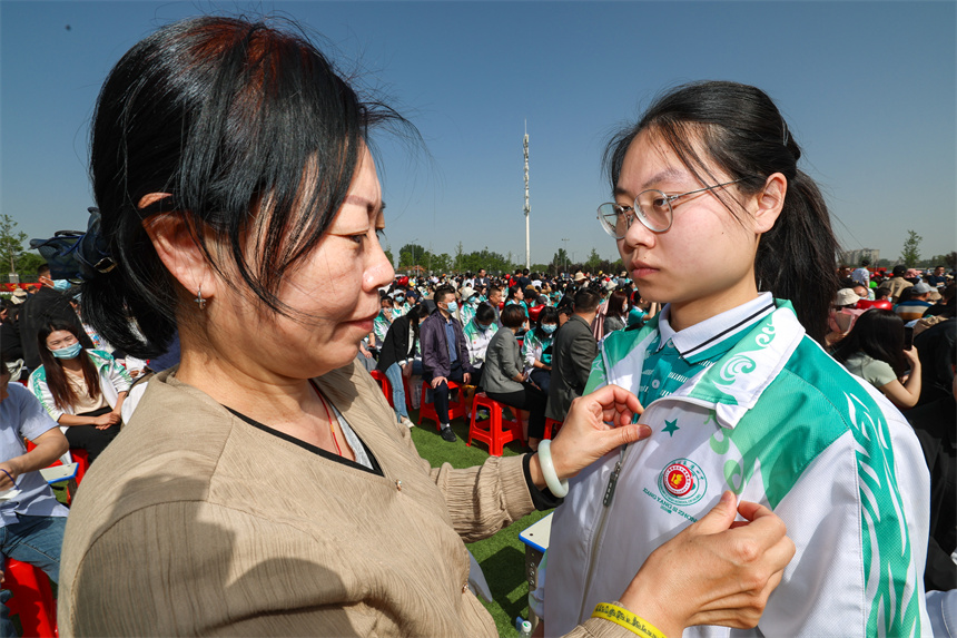 家長給孩子佩戴成人徽章。 