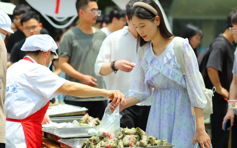 武漢輕工大學(xué)學(xué)生在領(lǐng)取粽子和鴨蛋。陳卓琳攝