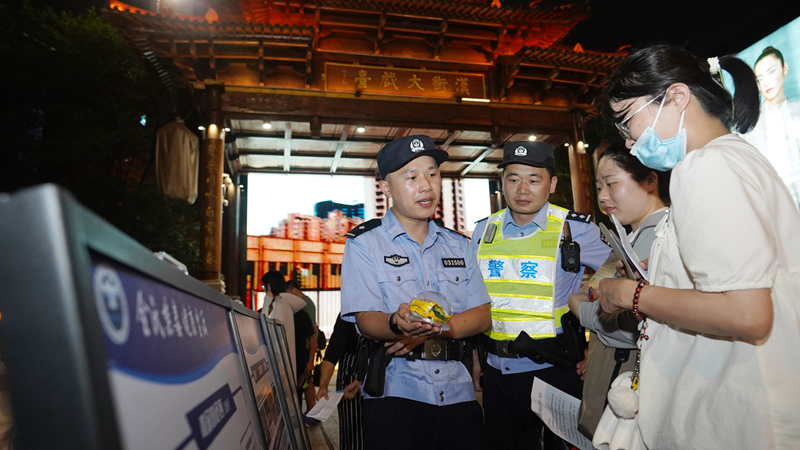 7月7日小暑時(shí)節(jié)，武昌區(qū)公安分局漢街派出所民警冒著夏日的炎炎高溫在漢街大戲臺向來往游客宣傳防騙禁毒知識。孫遜攝