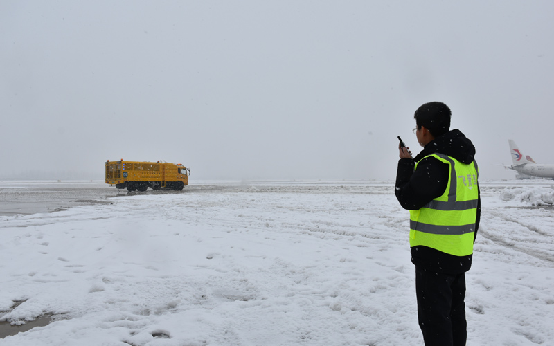 趙偉在機坪指揮吹雪車工作。天河機場供圖