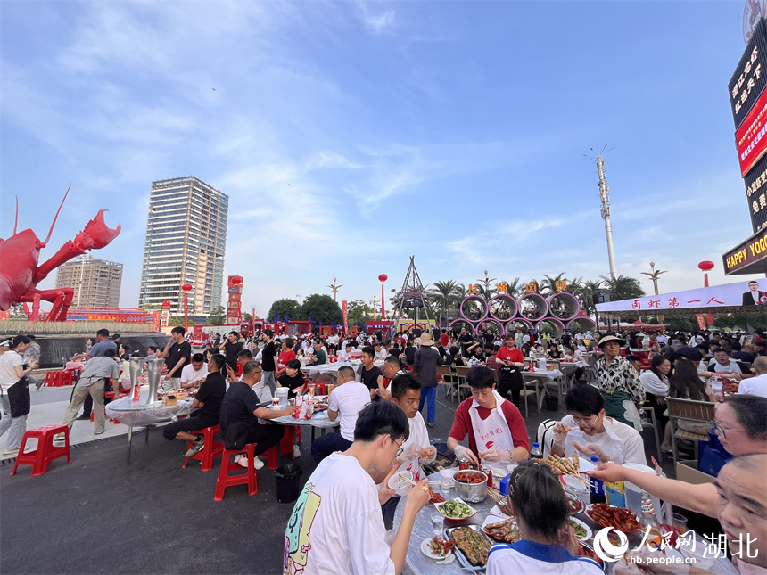 三五成群的食客手口并用，大快朵頤，品嘗著一盤盤色澤飽滿、醇香味美的小龍蝦。人民網(wǎng)記者 張雋攝