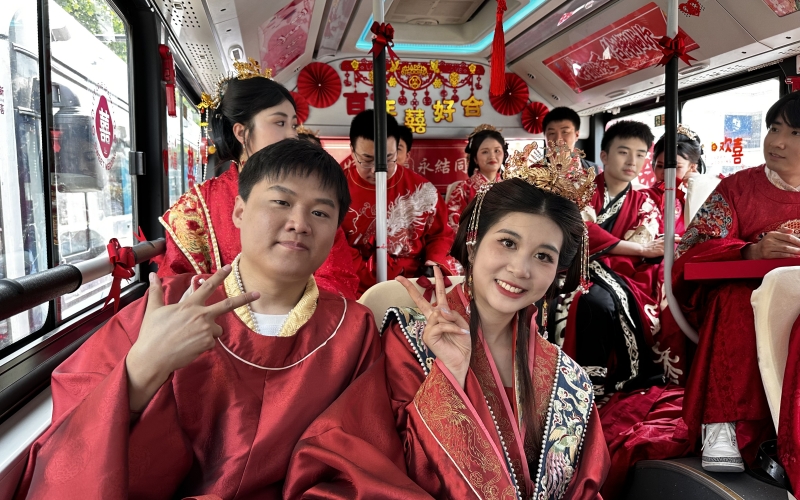 新人集體乘坐公交婚車，踐行低碳環(huán)保新風(fēng)尚。