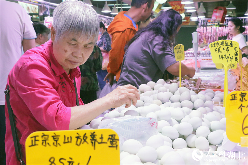 5月30日上午，一位老人在洪山廣場地鐵站菜市場挑選雞蛋。人民網(wǎng)記者 周恬攝