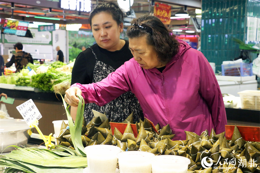 端午將至，洪山廣場(chǎng)地鐵站菜市場(chǎng)擺出了粽葉、手工粽子等節(jié)日美食，供市民挑選。人民網(wǎng)記者 周恬攝