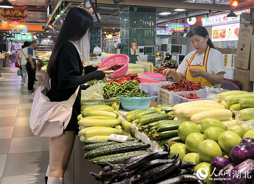 晚高峰時(shí)段，一年輕女子在洪山廣場(chǎng)地鐵站菜市場(chǎng)買菜。人民網(wǎng)記者 張雋攝