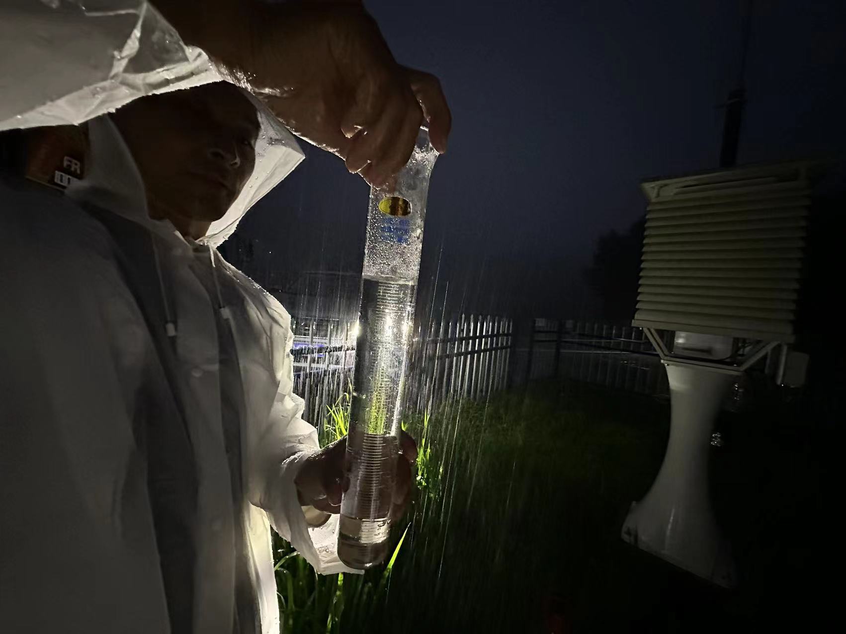 氣象觀測員雨夜核查觀測站降水量。朱慧麗攝