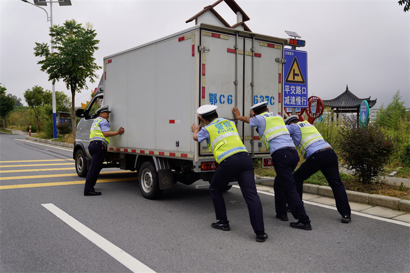 竹溪縣公安局交警大隊(duì)三中隊(duì)幫助廂式貨車處理故障。