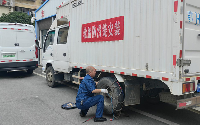 送貨司更換車輛防滑鏈。夏常貴攝